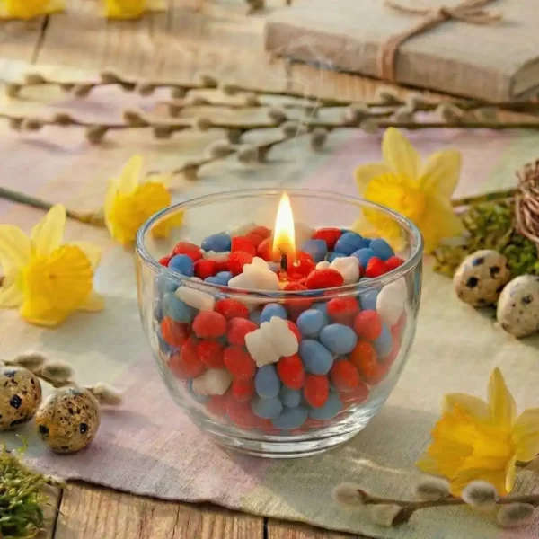 Spielkerze für Ostern rote und blaue Wachseier und weiße Wachshäschen auf Tisch für Ostern dekoriert